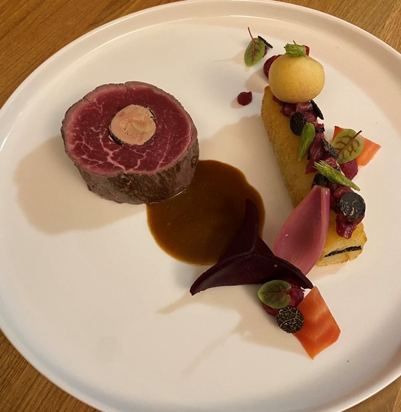 Filet de boeuf Herdshire, foie gras, truffe melanosporum, pressé de pommes de terre, chioggia rôtie, ravioles de betterave, beignet de sapin